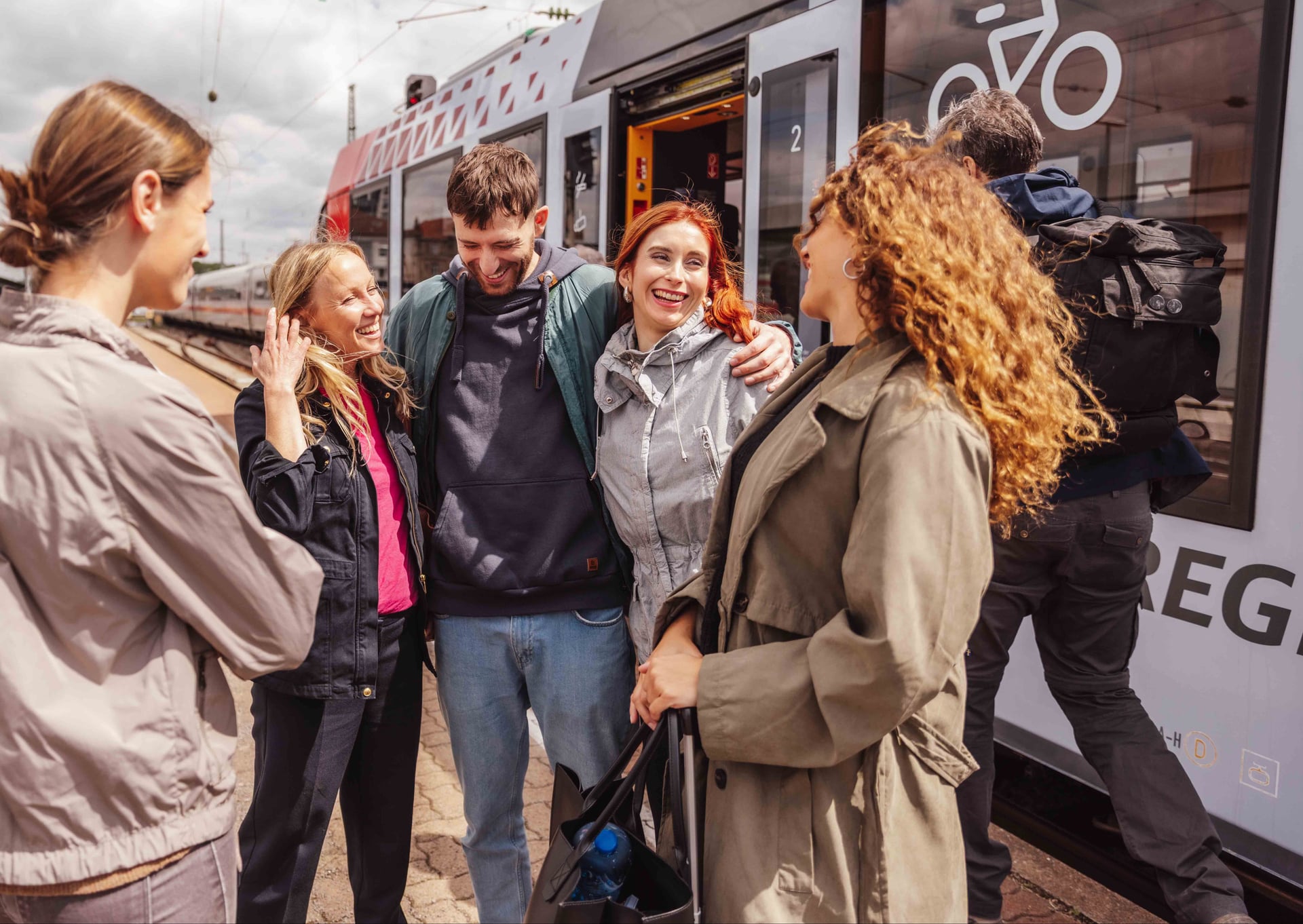 Freundesgruppe steht vor dem Zug