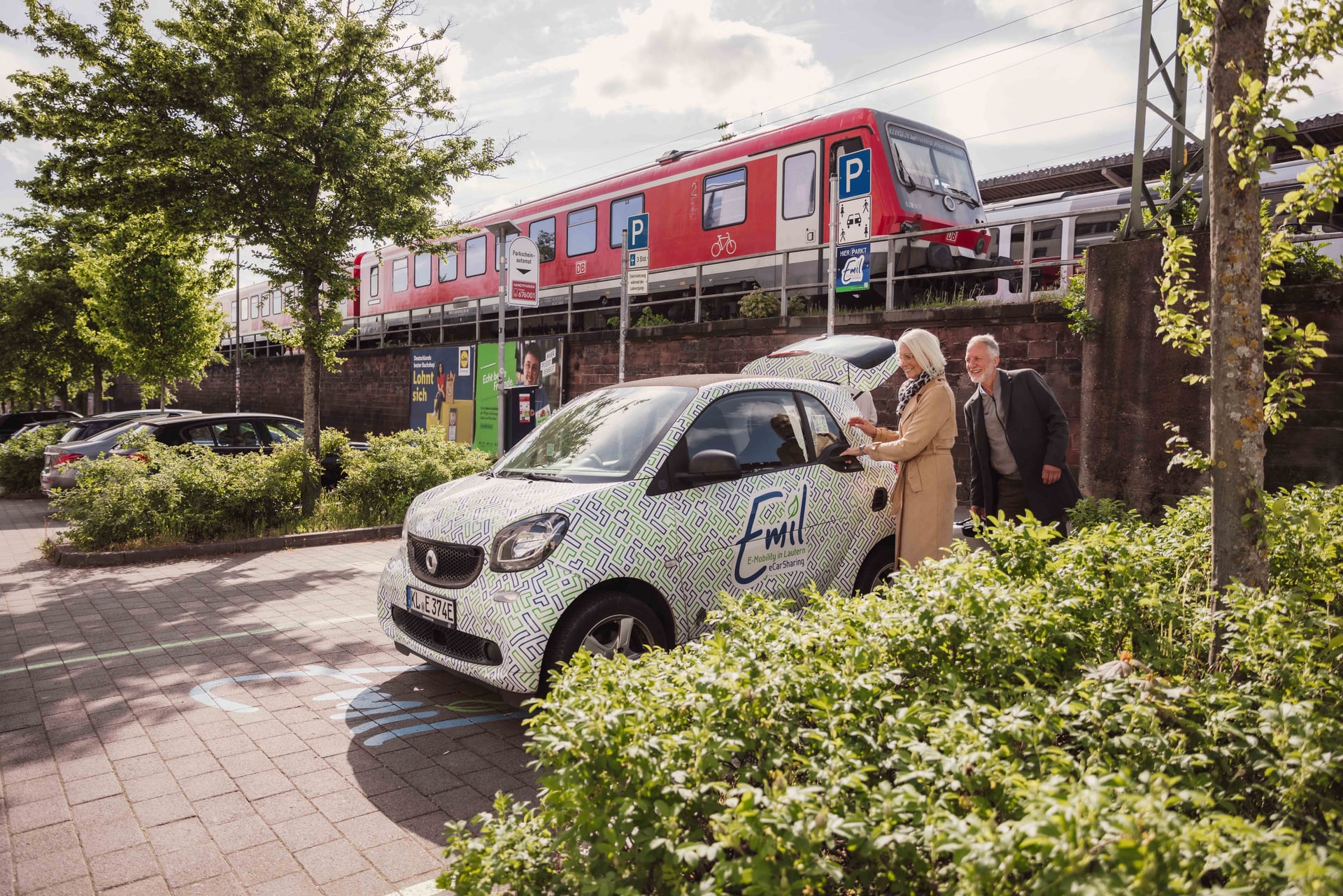 Pärchen ist auf einem Park+Ride-Parkplatz und nutzt das eCar Sharing