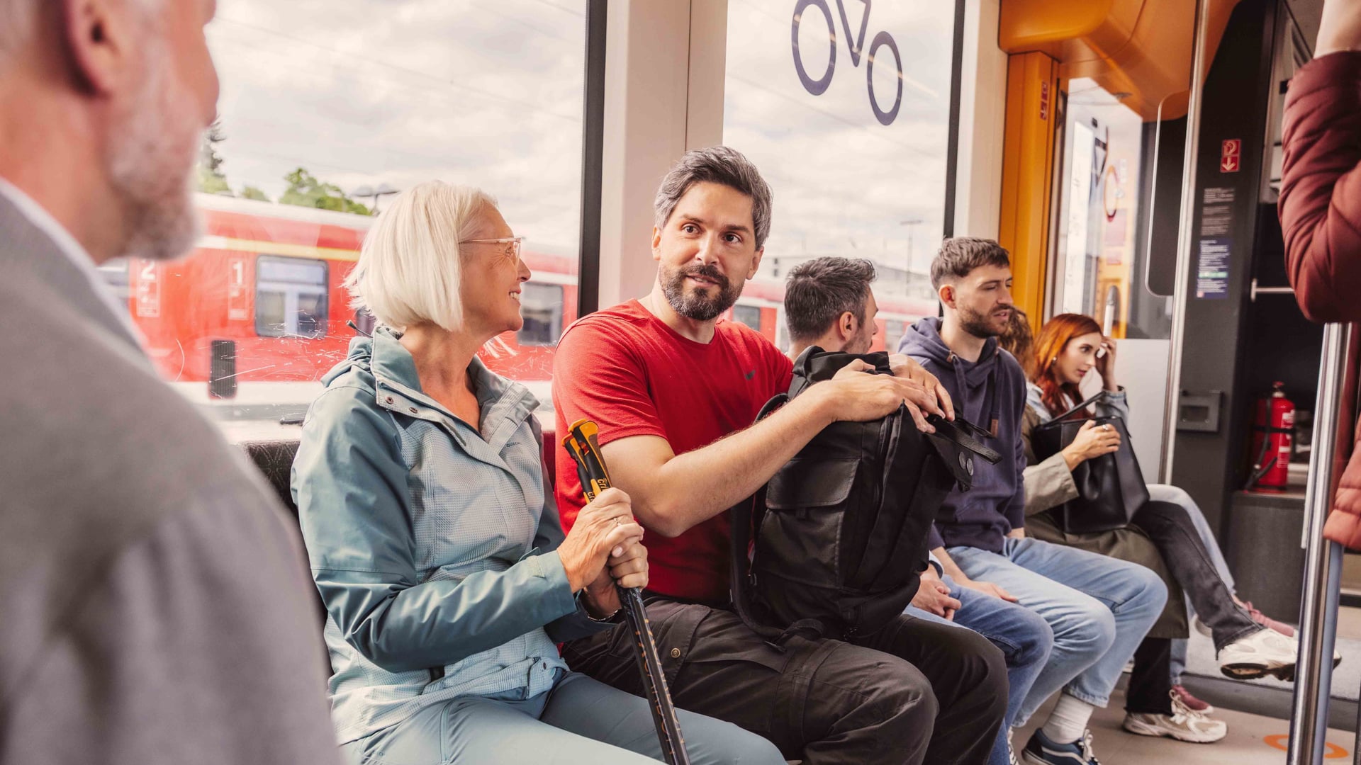 Mehrere Reisende sitzen im Zug im Fahrradabteil