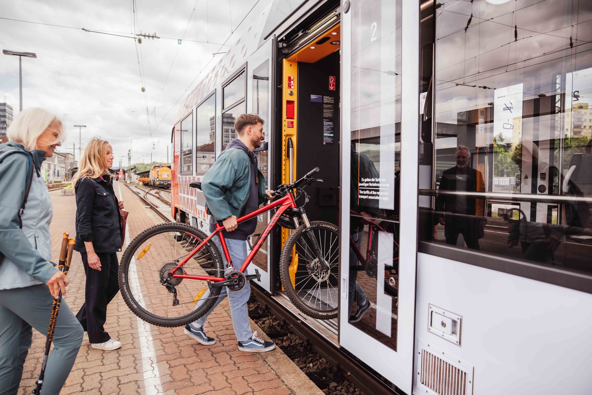 Mann hebt sein Fahrrad in den Zug